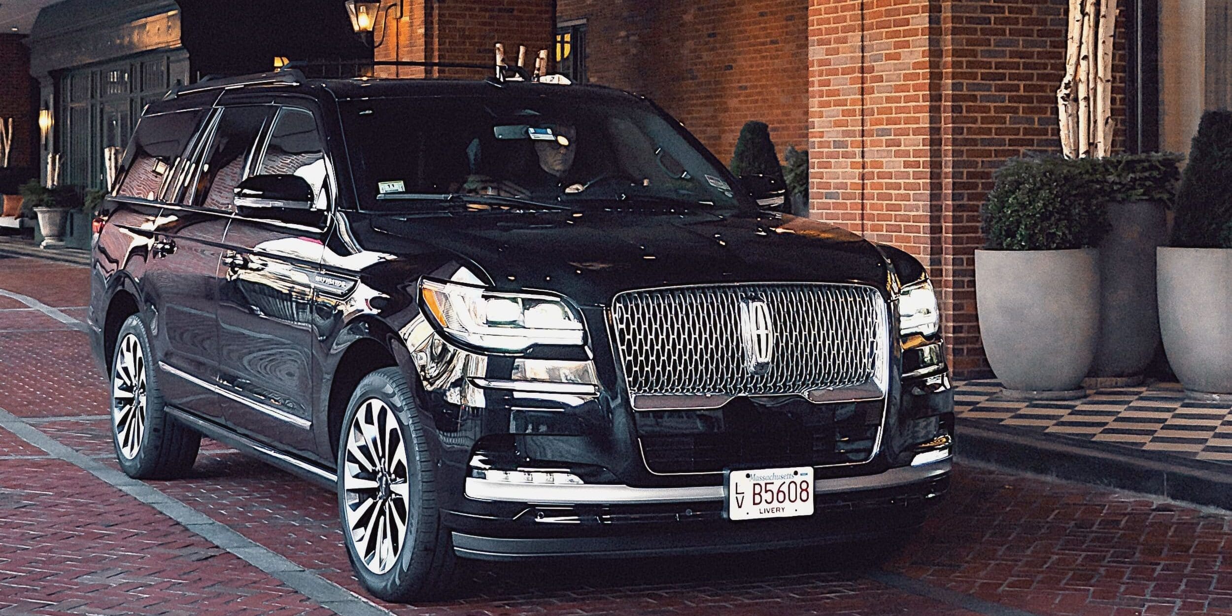 Black Lincoln Navigator parked at Four Seasons hotel entrance in Boston, ready for executive airport transfer.